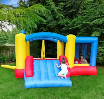 Red, yellow, and blue Toddler Bounce House + Slide set up outdoors with children